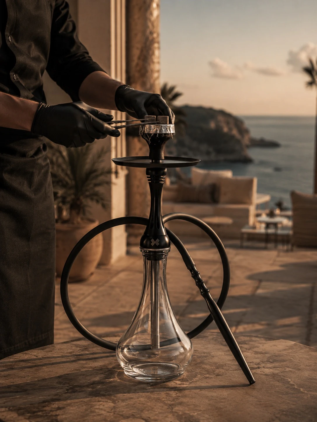 A hookah master prepares a hookah on the terrace